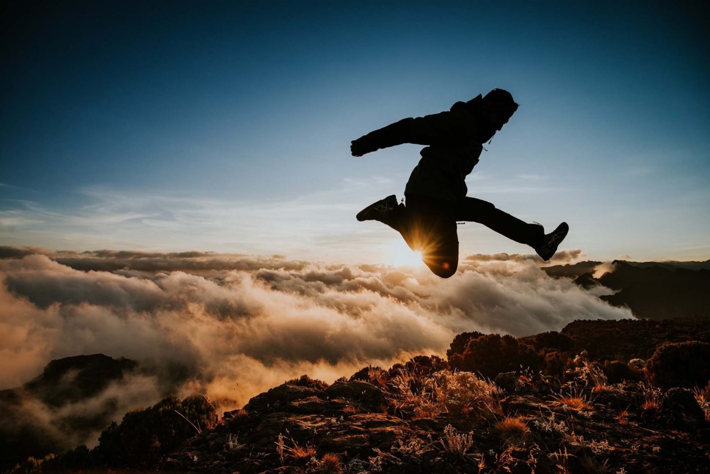 Picture of a man jumping above the clouds on Kilimanjaro