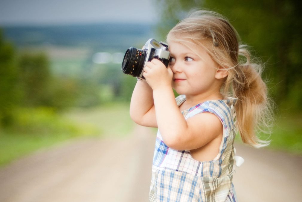 little girl taking photo on road trip