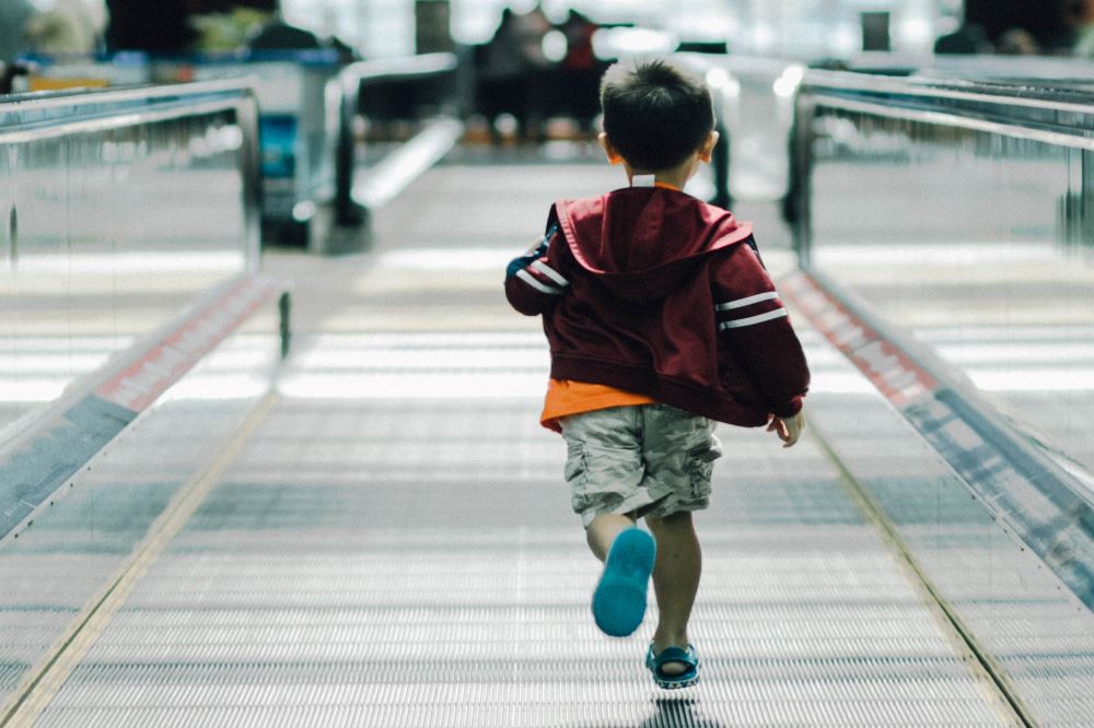 boy running in airport: single mum holidays travelling with hand luggage