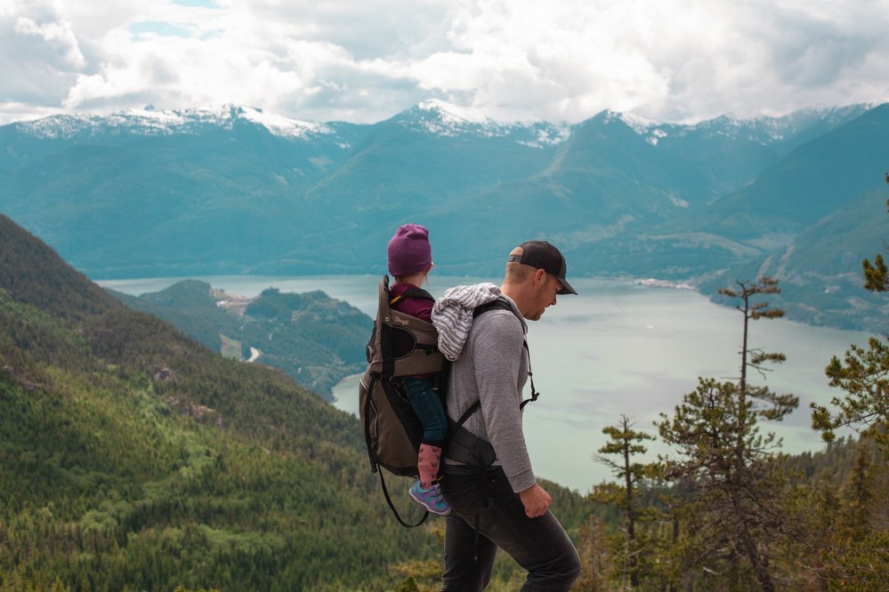 how to bond with kids on holiday - dad with daughter on backpack