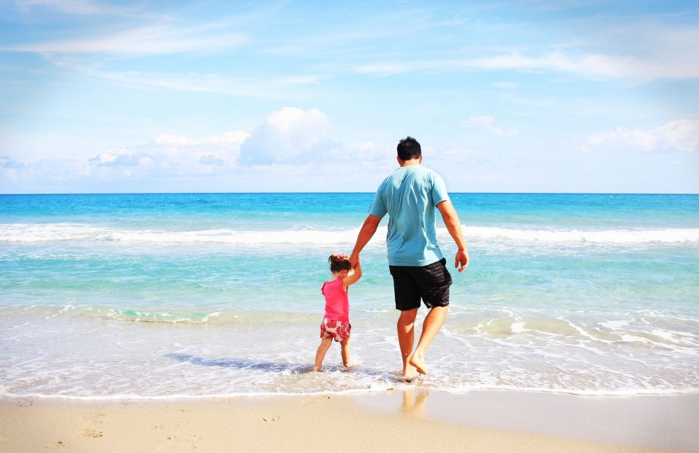 single dad holidays - dad with child on beach