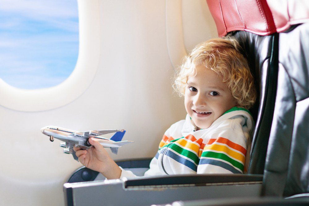 boy playing with toy plane on flight: flying with a disabled child