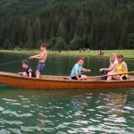 children in boat on lake
