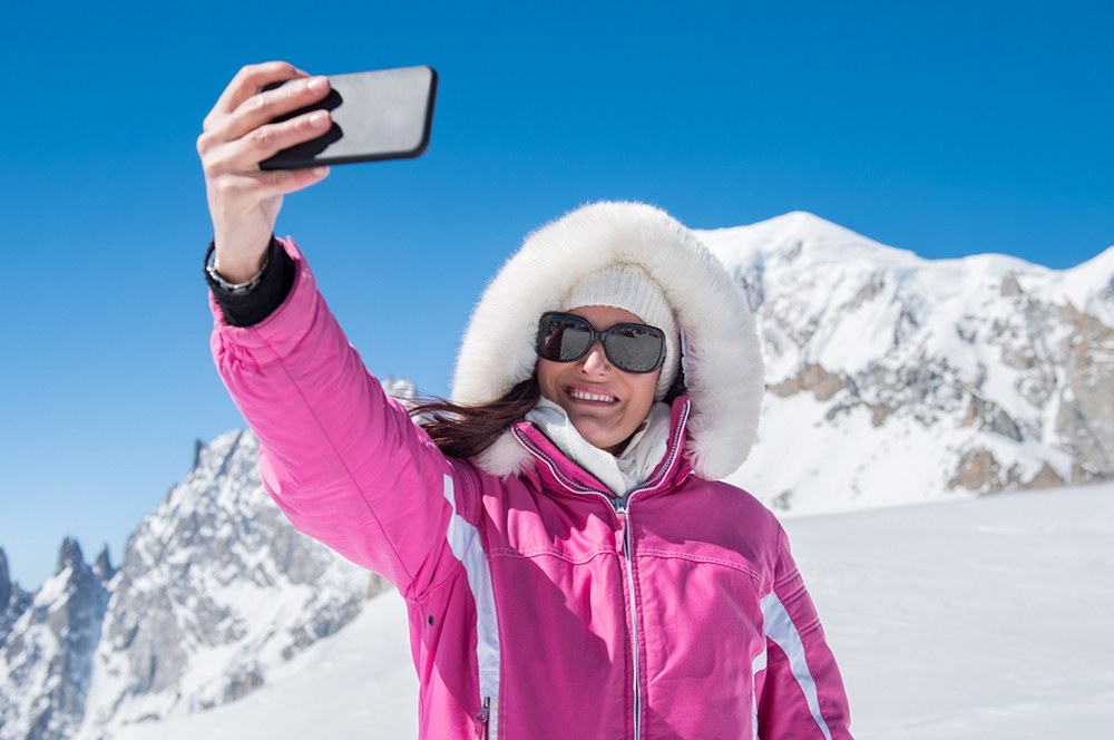 the ski holiday packing list - female skier taking selfie