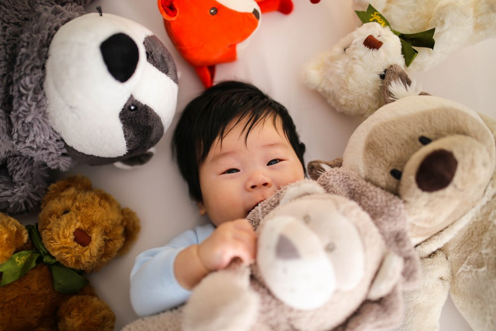 baby with lots of teddies and plush toys - cool kids bedroom