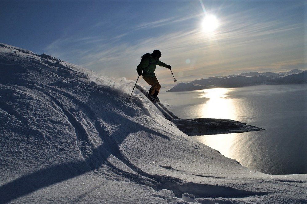 man skiing downhill on steep piste