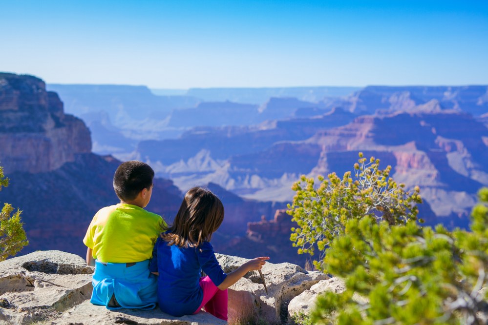girl and boy overlooking Grand Canyon on family travel to US