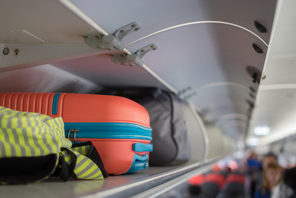 hand luggage in luggage compartment on plane