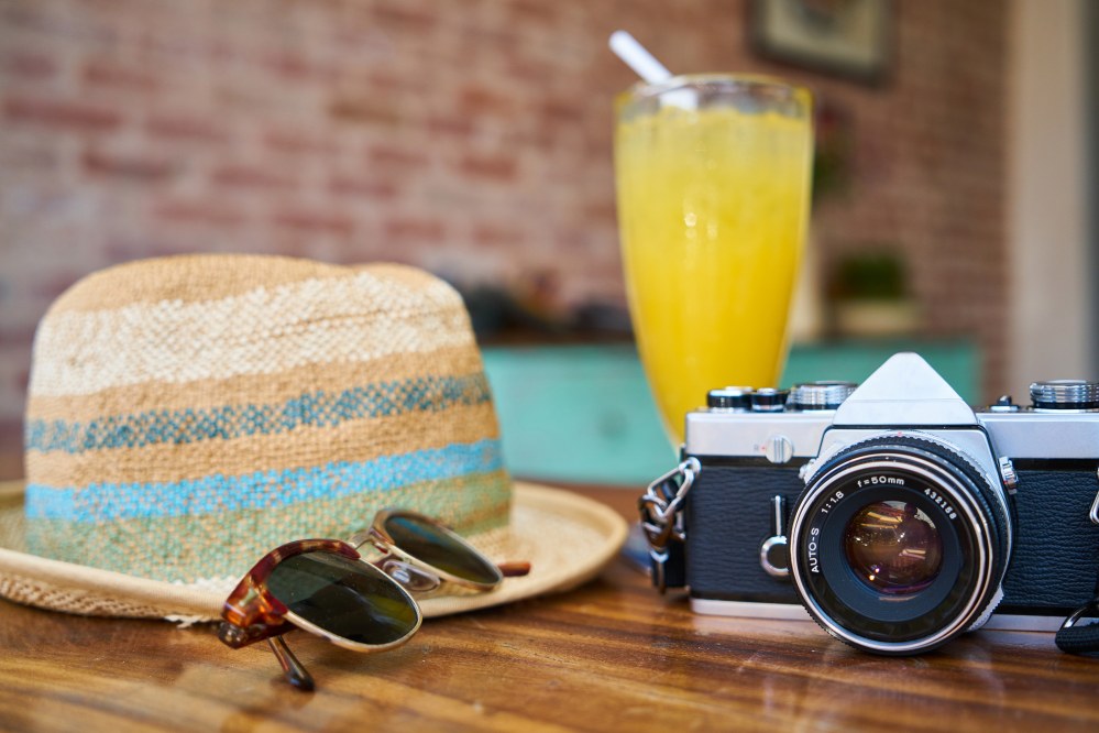 hat, sunglasses, camera: travel accessories of a sing traveller