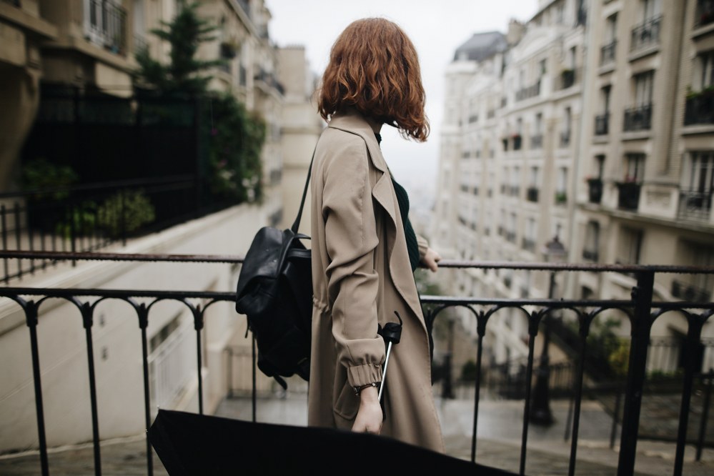 solo woman on city trip on bridge with umbrella