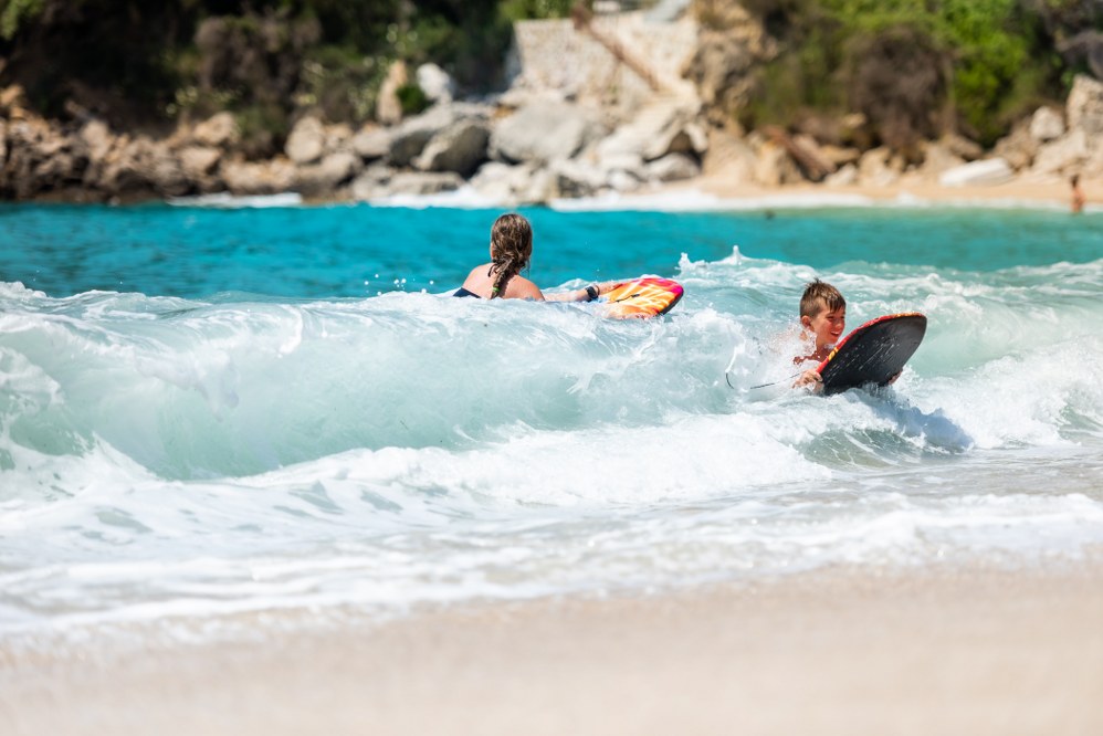 kids playing with surfboards in the sea