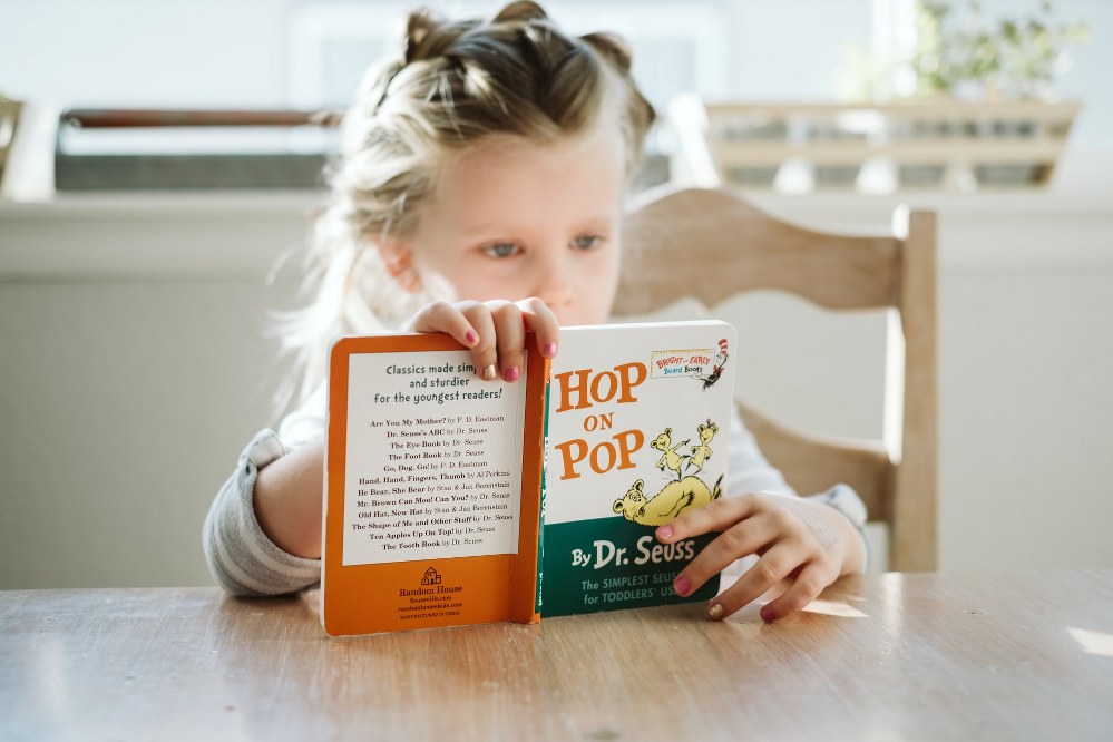 childrens books for single parents - girl reading Dr Seuss