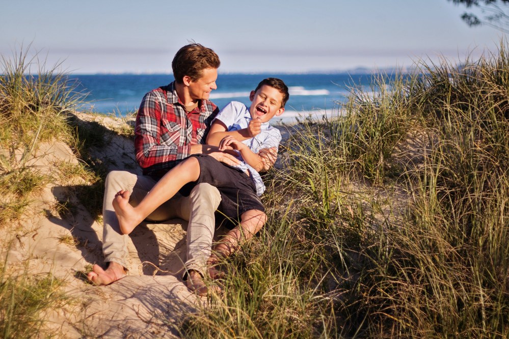 single dad and child having fun at beach