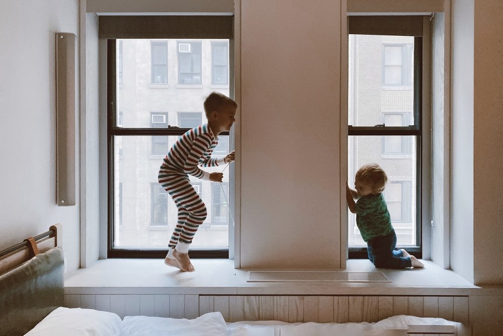 kids jumping on bed of new home - financial support for single parents