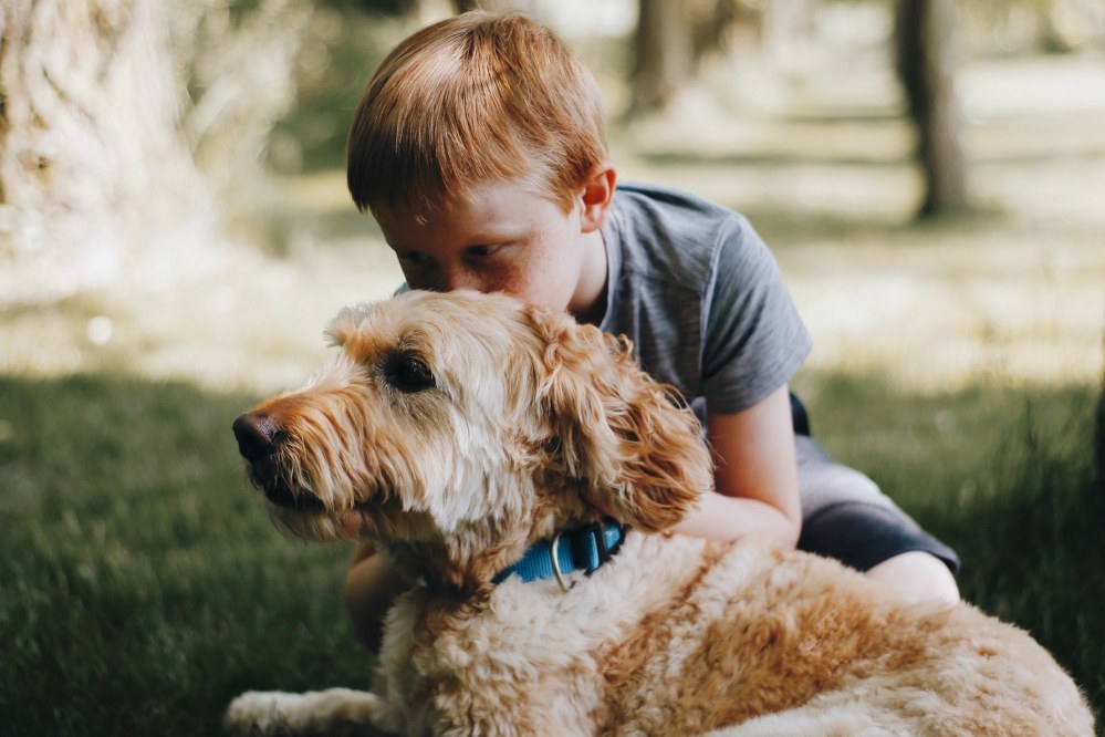 boy hugging his dog