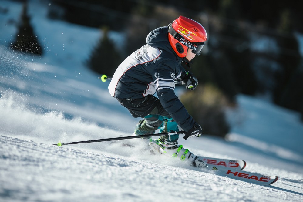 kid racing down the slope on ski holiday