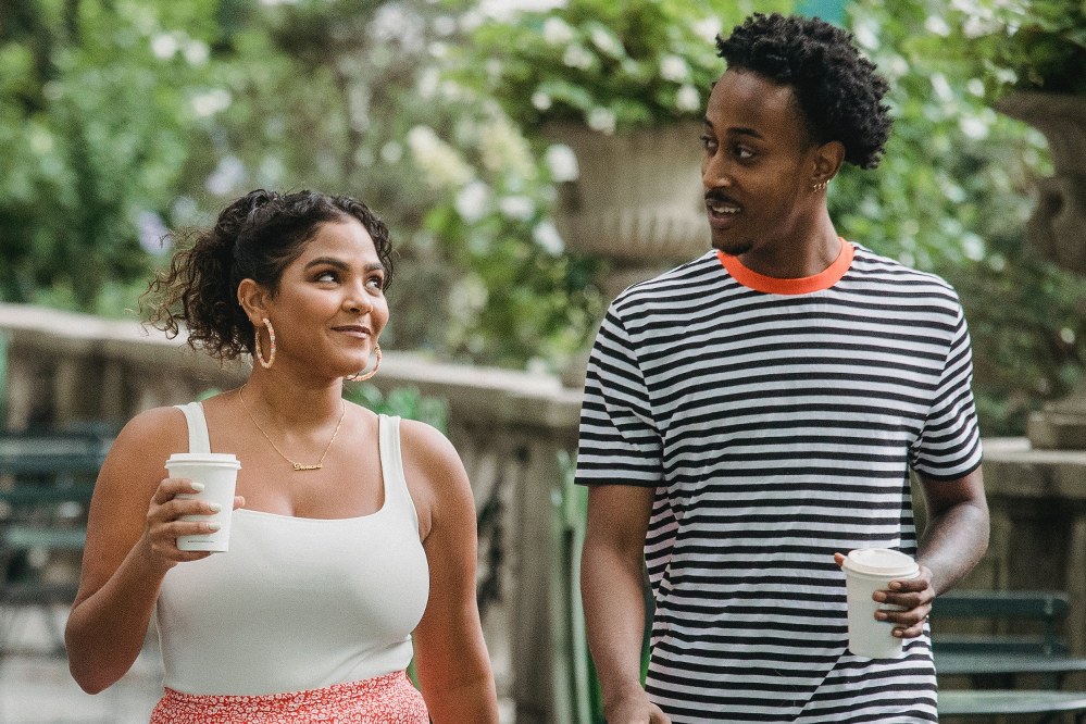 couple smile at each with coffee in hand other on walk