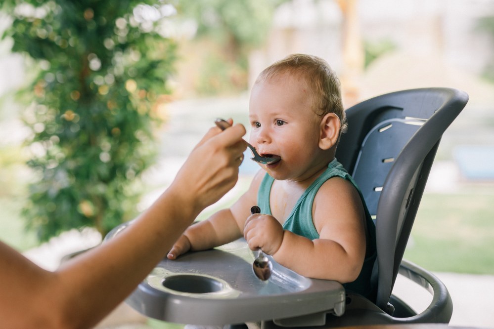 baby in high chair being fed