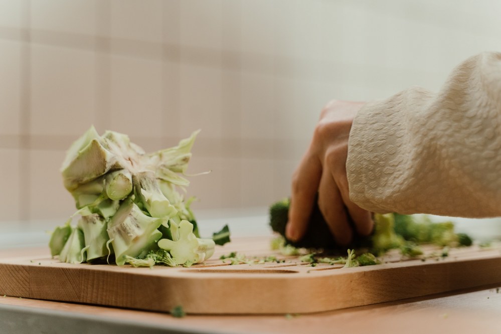 woman cutting vegetables on chopping board