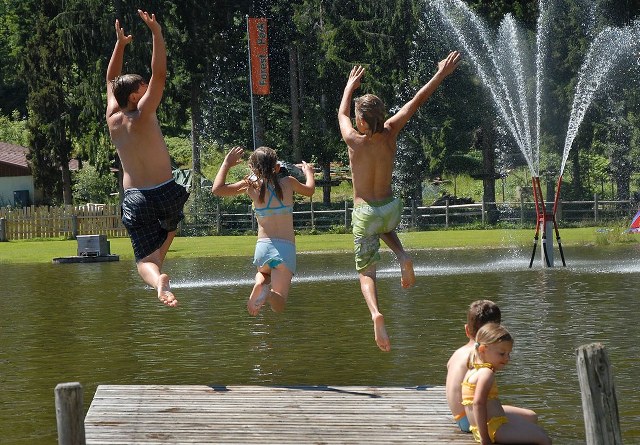 teens jumping in swimming lake Austria