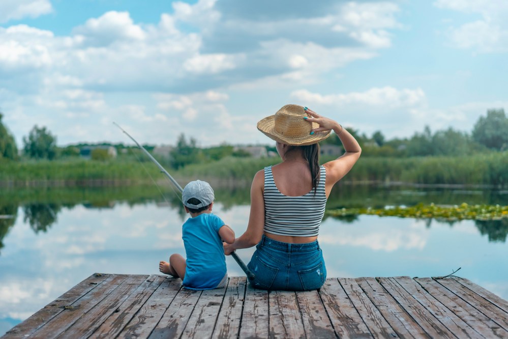 mum fishing with son on lake