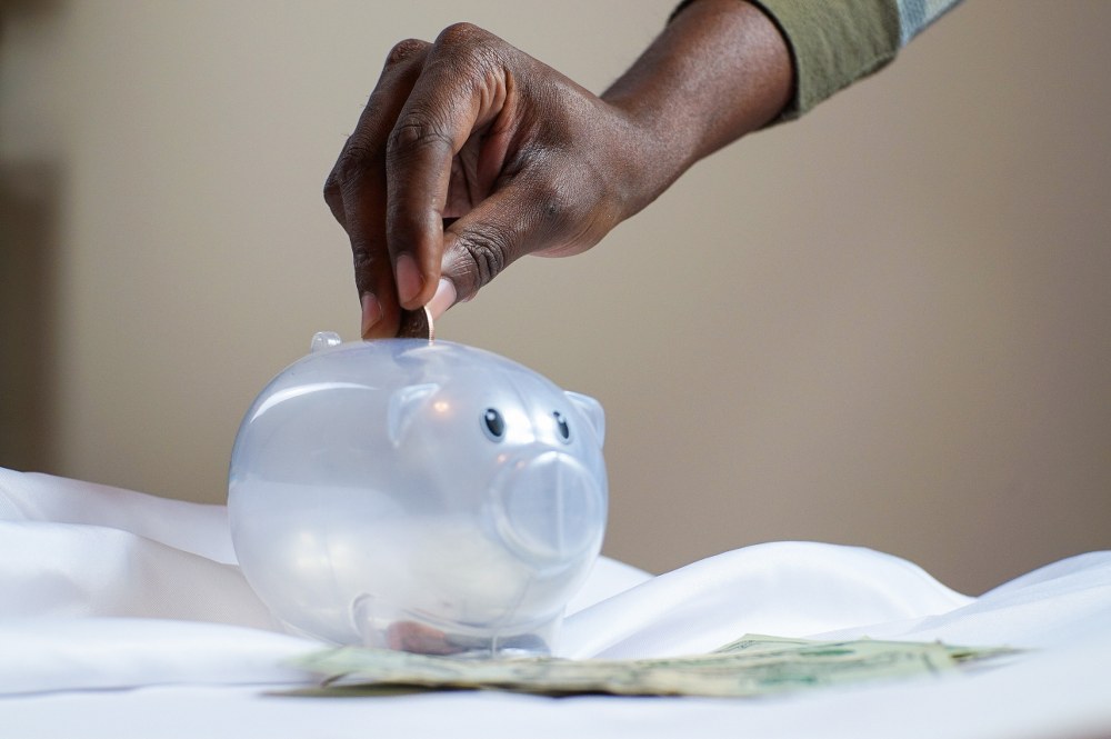hand putting money into piggybank