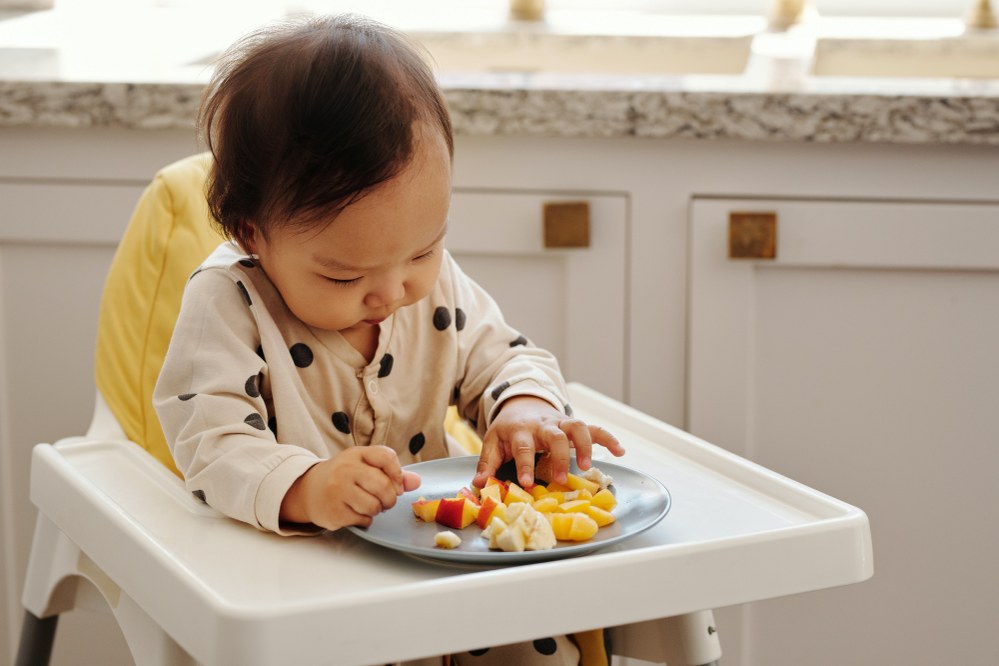 baby with plate of fruit