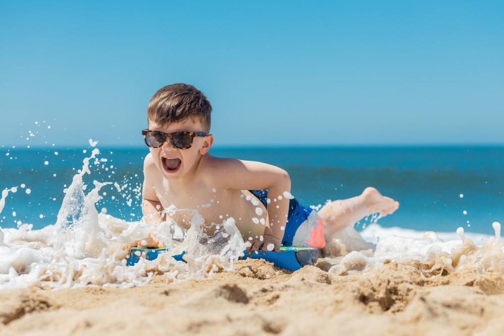 boy on surfboard on beach