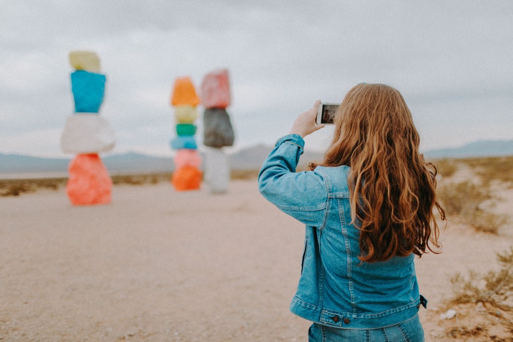 girl taking pictures at beach