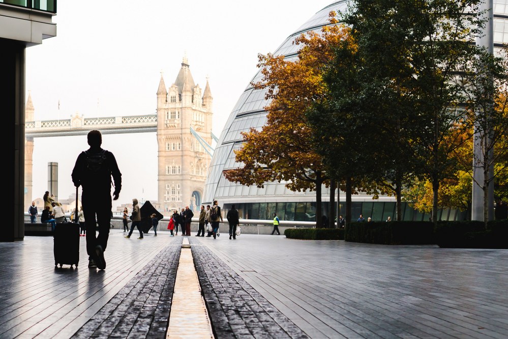 London tourist with suitcase walking towards tower bridge