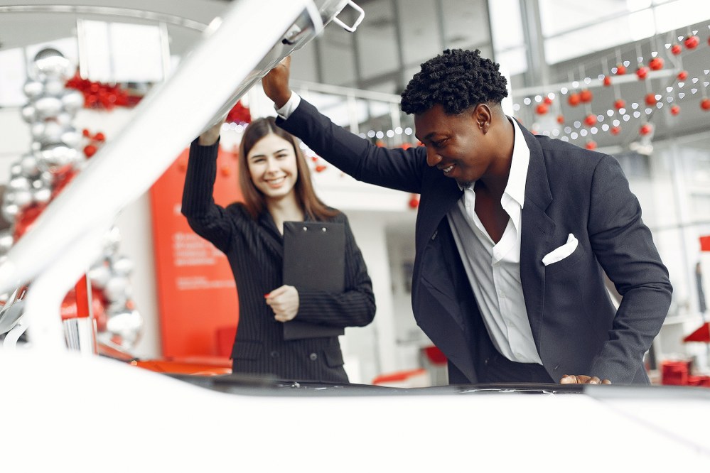 customer inspecting car at used car dealership