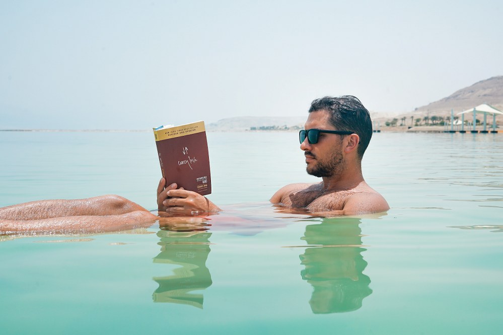 man reading book in the sea