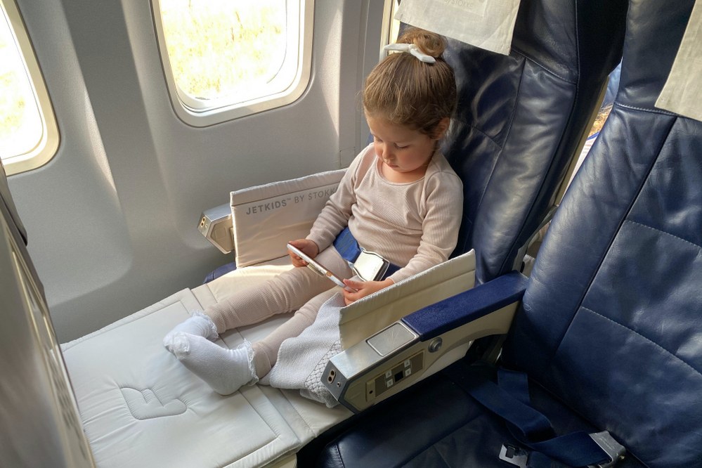 toddler on plane watching film on parent's phone
