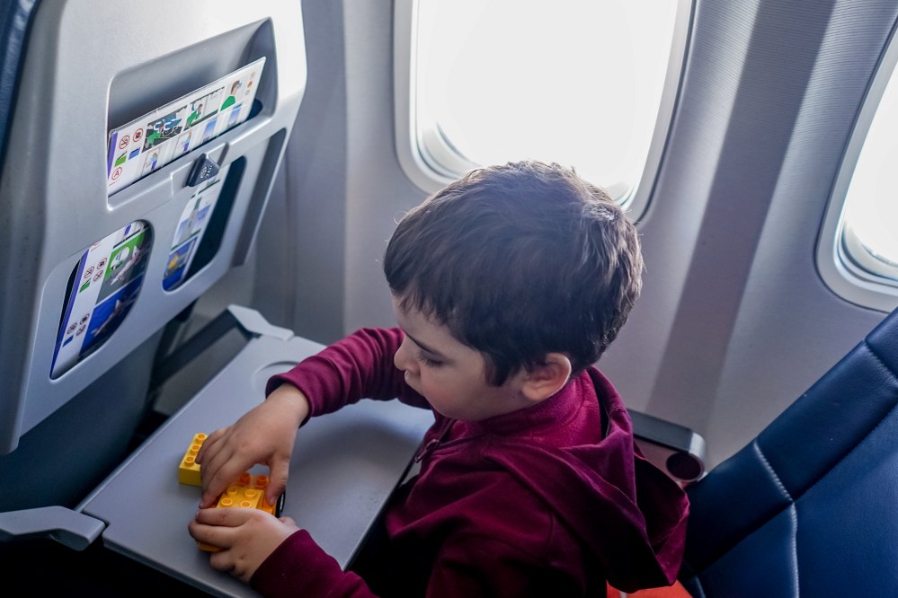 boy playing Duplo on airplane