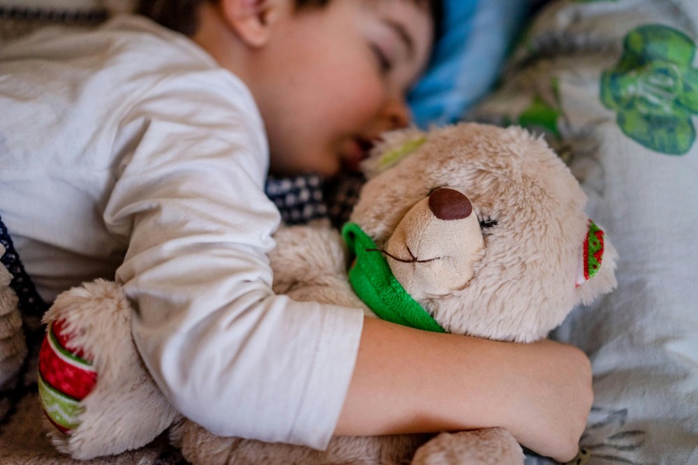 child sleeping with teddy