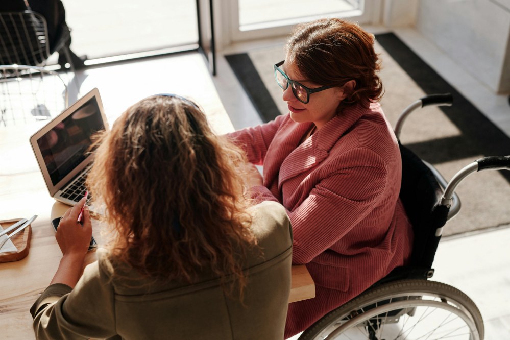 woman in wheelchair talking to another woman