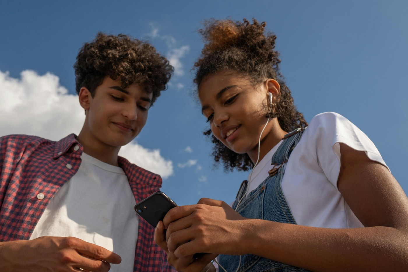 teenagers with mobile phone on family holiday