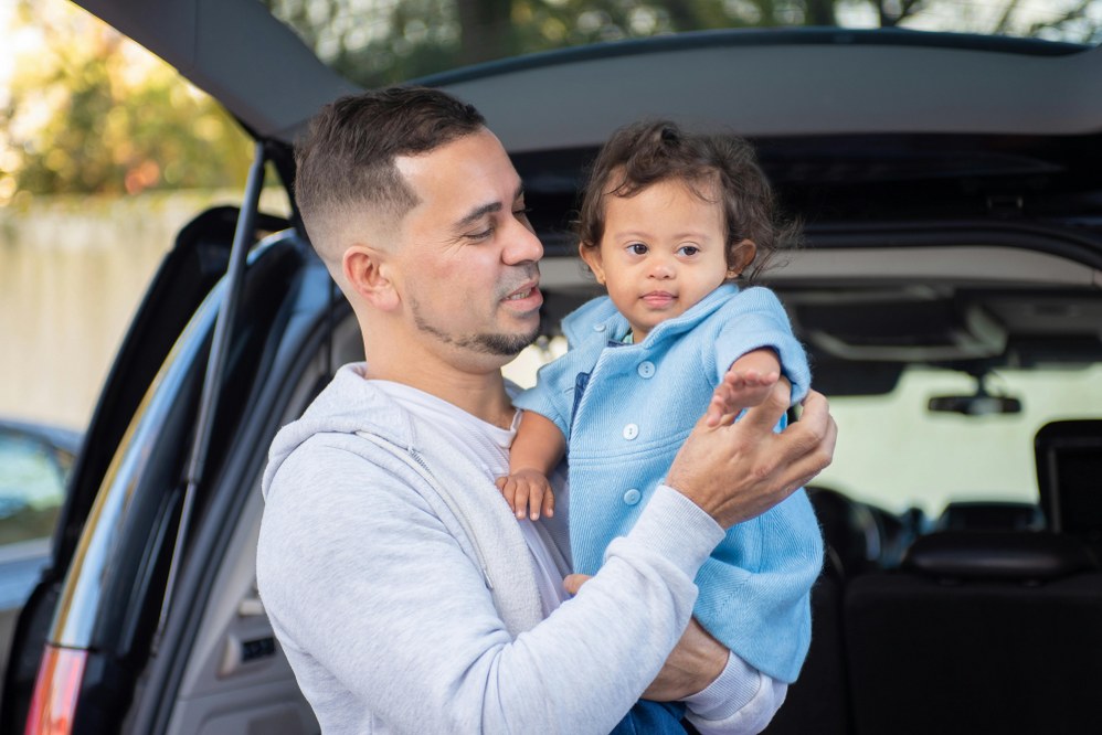 dad and daughter with Downs syndrome outside their car