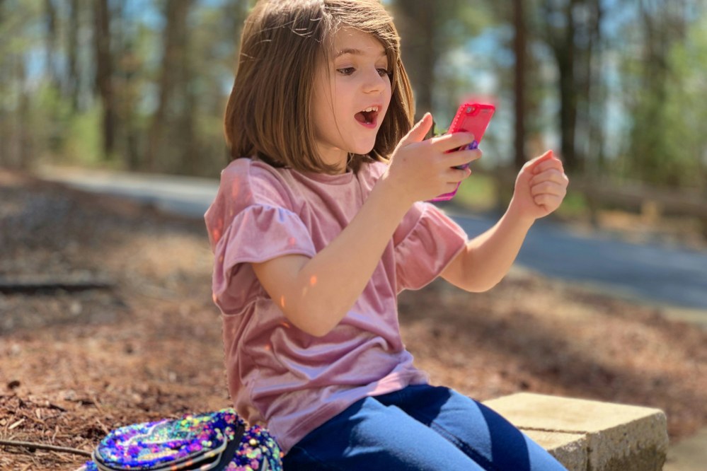 girl on holiday with mobile phone in hand