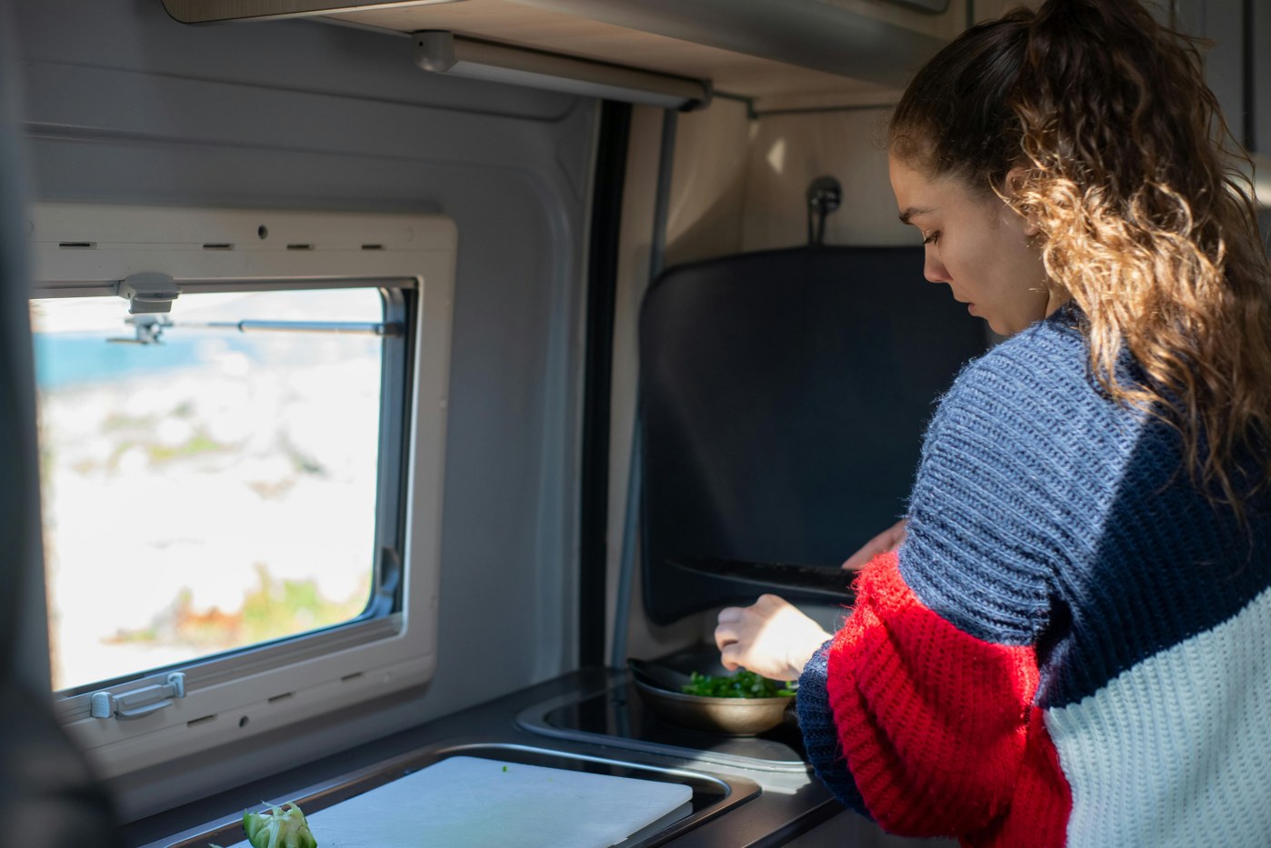 woman preparing food in motorhome kitchen