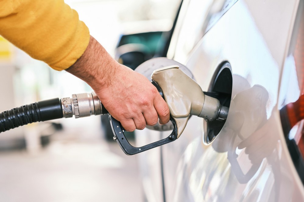 man getting fuel at petrol station - single parent road trips